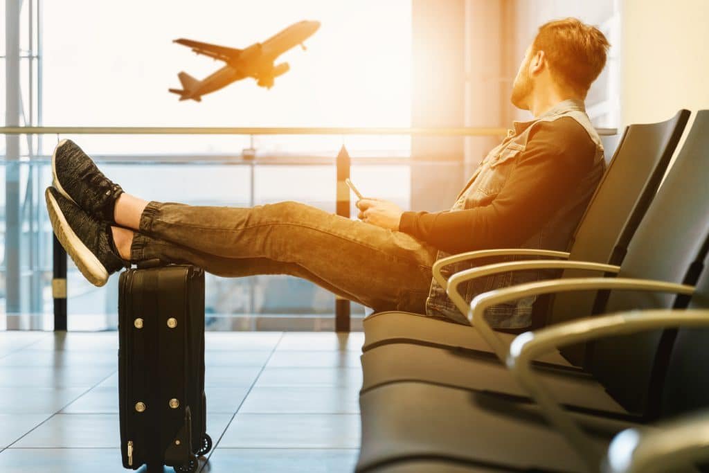 man waiting for plane in departures lounge