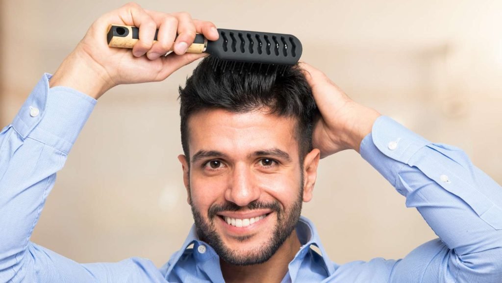 Hombre con cabello denso y sano usando un peine - Dr. Panno